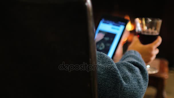 Descansar confortavelmente. Mulher com um copo de vinho no tablet lê as notícias sobre o fogo. Composição do espaço de cópia para títulos — Vídeo de Stock