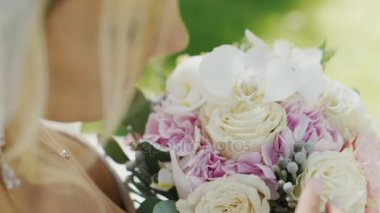 Sarışın gelin onun gelin buketi düşünüyor. Omuz üzerinden arka görünüm