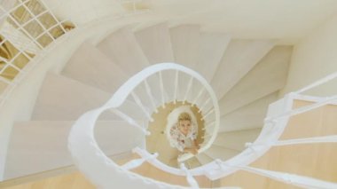 Güzel iç çamaşırı çekici gelin bir döner merdiven içinde duruyor. Yukarıdan görüntülemek