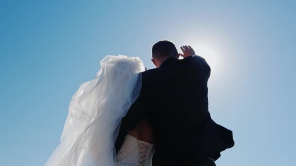 Νύφης και του γαμπρού κοιτώντας ψηλά, κλείνοντας τον ήλιο με το χέρι — Αρχείο Βίντεο