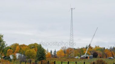 Grup çalışan işçiler, küçük bir çiftlik bir rüzgar türbini onarmaya hazırlanıyor. Vinç boom asansörleri