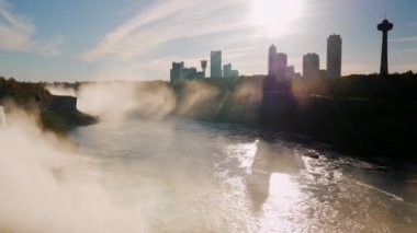 Sürükleyici show - günbatımı, Niagara Şelalesi'nde. Batan güneşin ışınları parlar aracılığıyla Kanada sahilde gökdelenler. Pan çekim