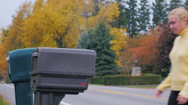 Çekici sarışın kadın posta posta kutusundan alır. Kırsal kesimde ABD