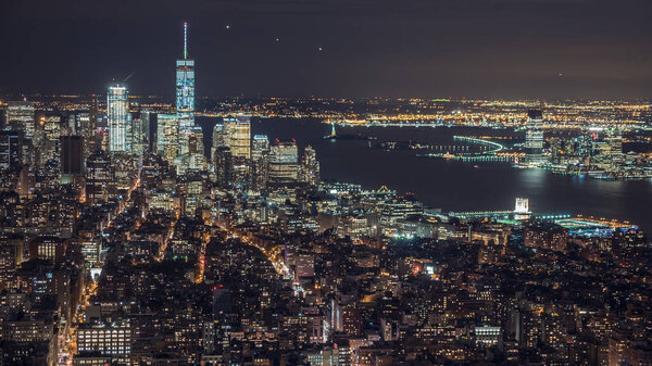 США, Нью-Йорк, панорама Манхэттена. Огни города ночью, движение автомобилей, самолетов и кораблей на реке
