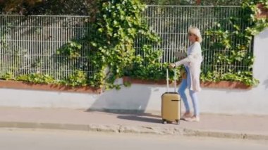 Turizm tatil beldesi sokakta yürürken tablet ve seyahat çantası