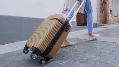 Avrupa ile seyahat. Bir kadın eski şehrin dar sokakta gezici bir çanta taşıyor. Sadece bacak ve bir çanta çerçevede görünür