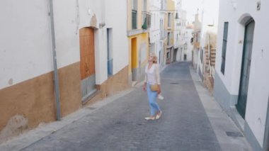 Avrupa'nın tarihi Ortaçağ kentin dar sokaklar boyunca genç kadın turist yürür. Çevresinde, mimari hayran görünüyor
