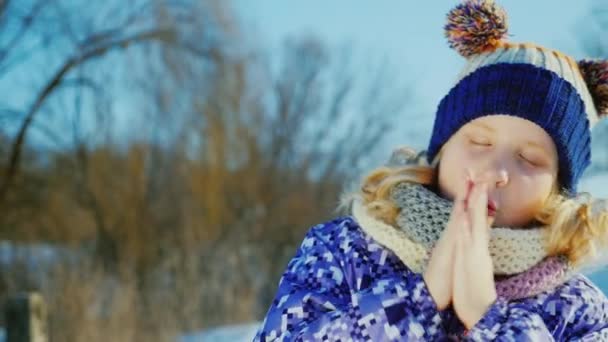 Χειμώνα πορτραίτο χαρούμενο κορίτσι 5 ετών. Κοιτάζει την κάμερα, ζεστό παλάμες — Αρχείο Βίντεο