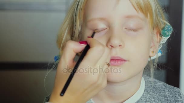 Портрет 5-летней девочки, делающей макияж. керлингисты на голове — стоковое видео