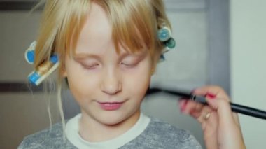 Curlers makyaj başında neşeli küçük kız. Biz bir çocuk tatil hazırlanma