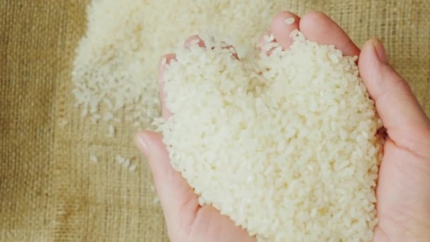 As mãos de mulheres idosas mantêm um grão de arroz — Vídeo de Stock