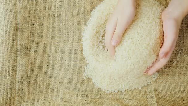 Dos pares de manos: una mujer adulta y un niño sostienen un grano de arroz — Vídeos de Stock