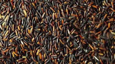 Bir damlama aşağı düşen siyah pirinç tanelerinin. Pirinç ile dönen yüzey