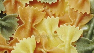 Farklı renklerde kurdeleler şeklinde pişmemiş makarna