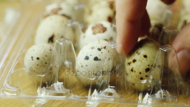 La mano toma huevos de codorniz en un recipiente de plástico. Alimentación y dieta saludables — Vídeos de Stock