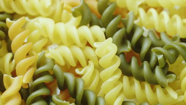 Uncooked pasta in the form of spiral of different colors — Stock Video