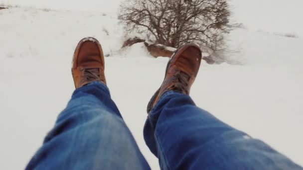 Snabba nedstigningen från de snötäckta bergen. I bild syns manliga benen i stövlar. POV video — Stockvideo