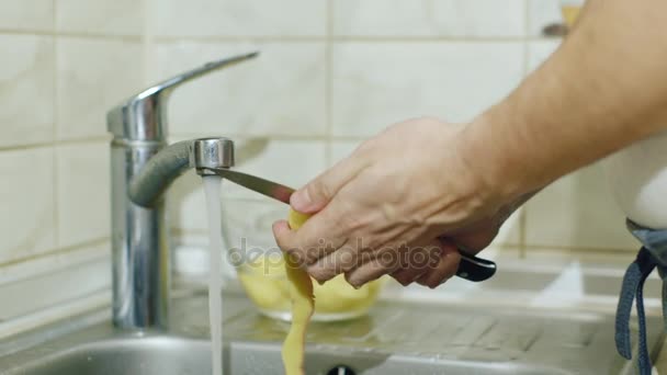 Bacharel. O homem na cozinha descasca batatas — Vídeo de Stock