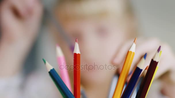 Crayons de couleur brillants. Blonde fille choisit un dessin au crayon, faible profondeur de champ — Video