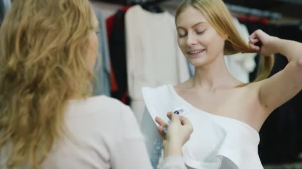 Vendedor consultor ayuda a los compradores a probar la joyería. El departamento de ropa y accesorios para mujer — Vídeos de Stock