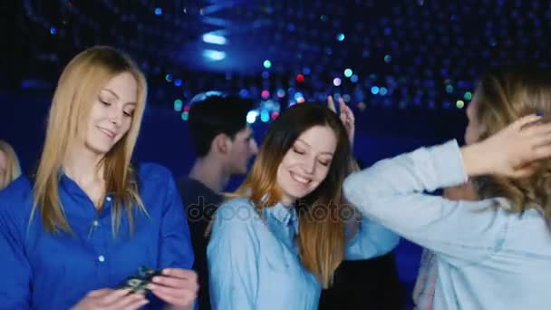Eine Gruppe junger Leute, Männer und attraktive Frauen tanzen in einer Diskothek — Stockvideo
