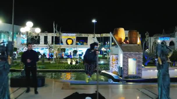 Sharm el Sheikh, Egitto, marzo 2017: Steadicam girato Passeggiata lungo la famosa piazza Soho. Le luci della notte brillano, turisti, attori e belle statue camminano — Video Stock