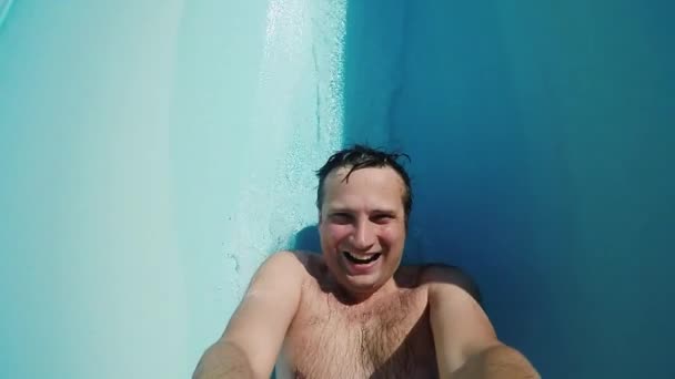 Un uomo divertente sta cavalcando su uno scivolo d'acqua. Video di rallentatore POV — Video Stock