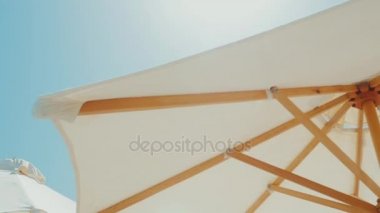 Beyaz şemsiye mavi gökyüzü. Beach tatil beldesi. Steadicam atış