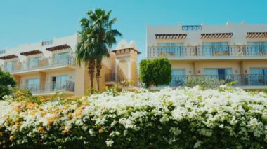Sharm el Sheikh, Mısır, Mart, 2017: resort, çiçekli lushly ön planda bina çalılar, avuç içi. Güneşli bir günde dinlenmek için güzel bir yer