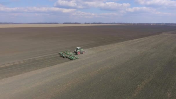Venkovská krajina - traktor běží v poli. Brzy na jaře, slunečný den — Stock video