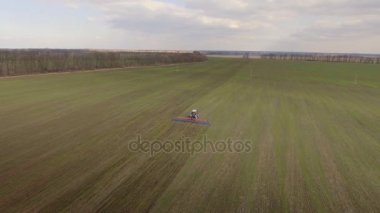 Traktör erken ilkbaharda - uzun menzilli planı, hava anket alanında çalışan