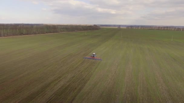Трактор работает в поле ранней весной - дальнобойный план, аэросъемка — стоковое видео