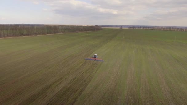 Ciągnik jest praca w polu wczesną wiosną - plan dalekiego zasięgu, Loty patrolowe — Wideo stockowe