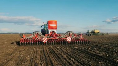 Atış Steadicam: iki Traktörler ile tohum ekmek buğday alanında erken ilkbaharda. Arkadan Görünüm