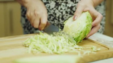Yakın çekim yaşlı bir kadın elinde. Dilimleri lahana salatası