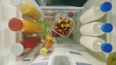Gece snack ve sağlıksız yaşam tarzı. Buzdolabı içinde-bir görünümden kadın el tatlılar bir tabak al.