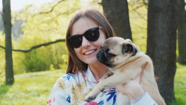 Portrait of a stylish young woman with a mobs on her hands. Favorite dog, kiss and play with the puppy — Stock Video