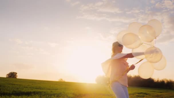 Giovane donna spensierata con palloncini cammina su un prato verde ... Sognare prato verde