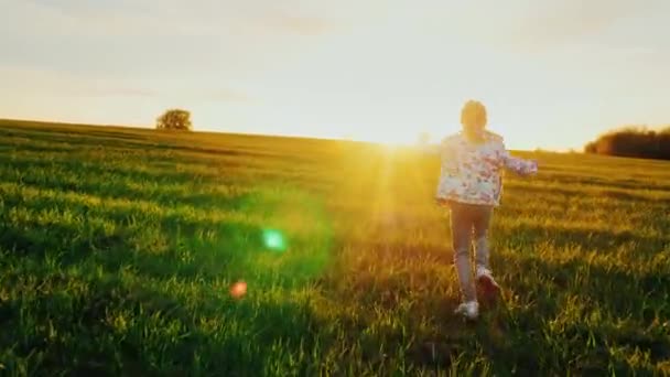 Un bambino spensierato corre felicemente attraverso il prato verde ... Sognare prato verde
