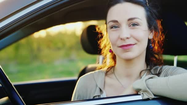 Orta yaşlı kadın bir araba, gülümseyen, portre pencereden dışarı bakarak — Stok video