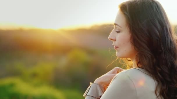 Retrato de perfil de una joven. Disfrutando de la puesta de sol en un cálido día de primavera — Vídeo de stock