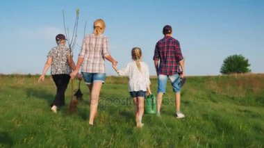 Arkadan Görünüm steadicam vurdu: birkaç nesil aile ağacı fidan ile gelir. Kız sulama silah taşıyor, annesi ve büyükannesi elma fidan taşıyoruz.