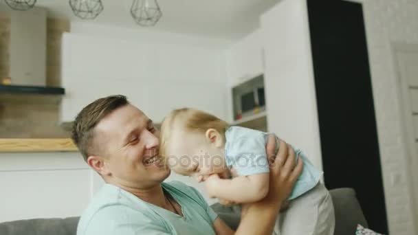 Um jovem pai caucasiano brinca com um filho de 10 meses. Ao lado deles está o seu cão favorito - o terrier da raça — Vídeo de Stock