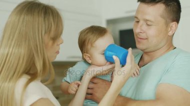 Çocuk bardaktan su içer. Ailesi holding