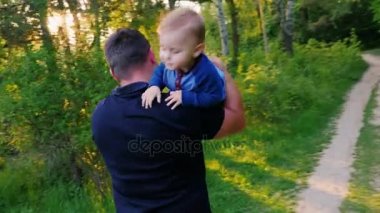 Mutlu baba ile bebek oğlu çalış. Onu güzel bir park omzundan sürdürmektedir
