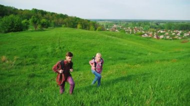 Ön görünüm: sırt çantaları turistlerle birkaç yükselişi geniş bir yeşil tepe tepesine. Mavi gökyüzü arka planı. Kavram - başarı, başarıları, spor