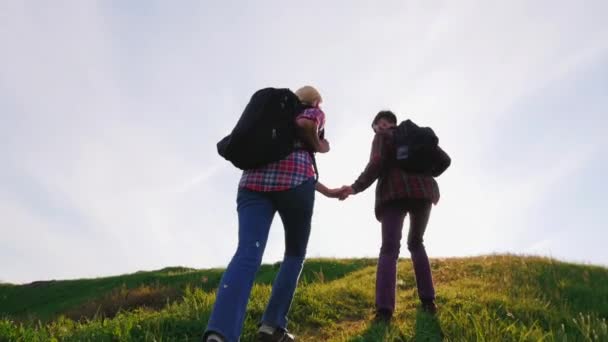 Helping hand. A young male tourist helps to climb up a woman. Steep ascent on a hot day — Stock Video