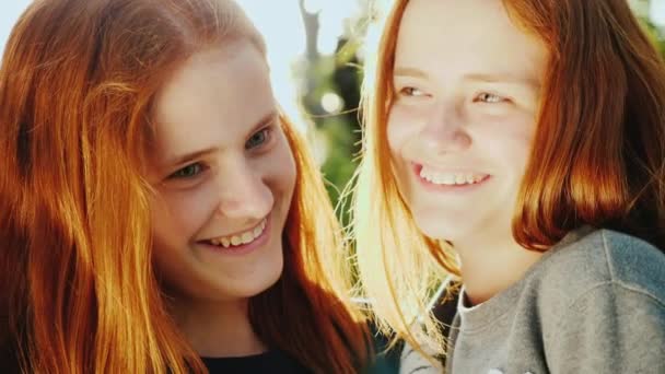 Happy twin sisters bathe in the sun. Smile, look at the camera — Stock Video