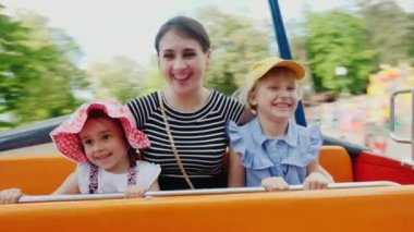 İki çocuklu genç bir anne bir cazibe biniyor. Çocuk gülmek, iyi eğlenceler. POV video