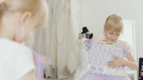 6 ετών νεαρή κοπέλα που προσπαθεί στο κομψό φόρεμα μπροστά από έναν καθρέφτη — Αρχείο Βίντεο